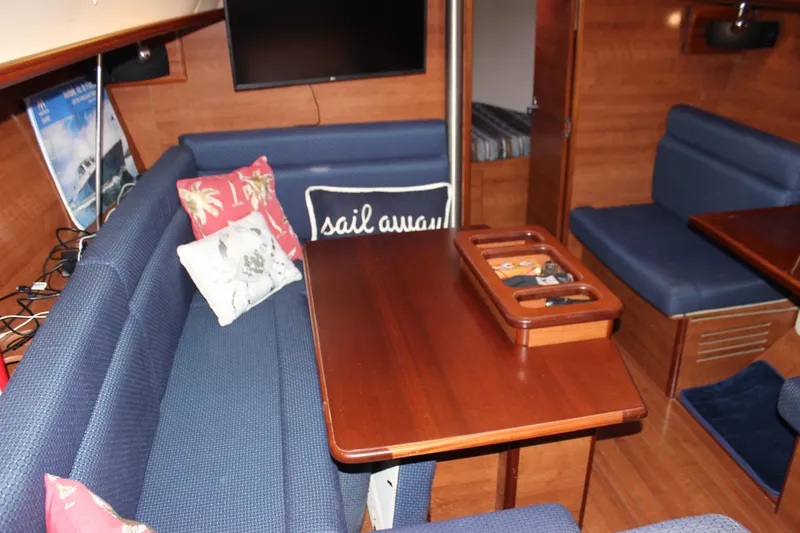  Yacht Photos Pics Interior of a 2014 Hunter 33 sailboat with blue seating and wooden table.