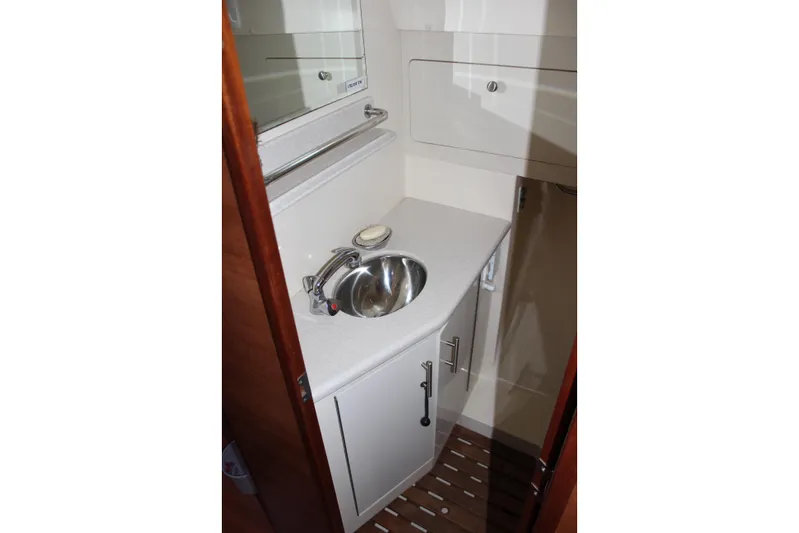  Yacht Photos Pics Compact bathroom sink area in 2014 Hunter 33 yacht, featuring modern fixtures and storage.