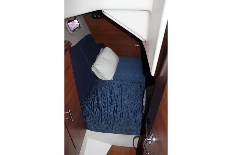  Yacht Photos Pics 2014 Hunter 33 yacht cabin interior with blue bedding and wooden finish.