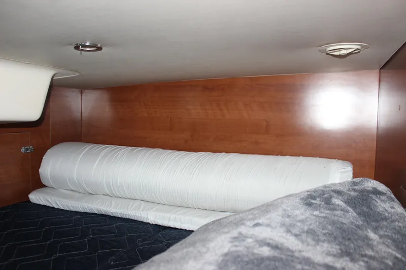  Yacht Photos Pics Interior cabin of 2014 Hunter 33 sailboat with wooden paneling and bedding.