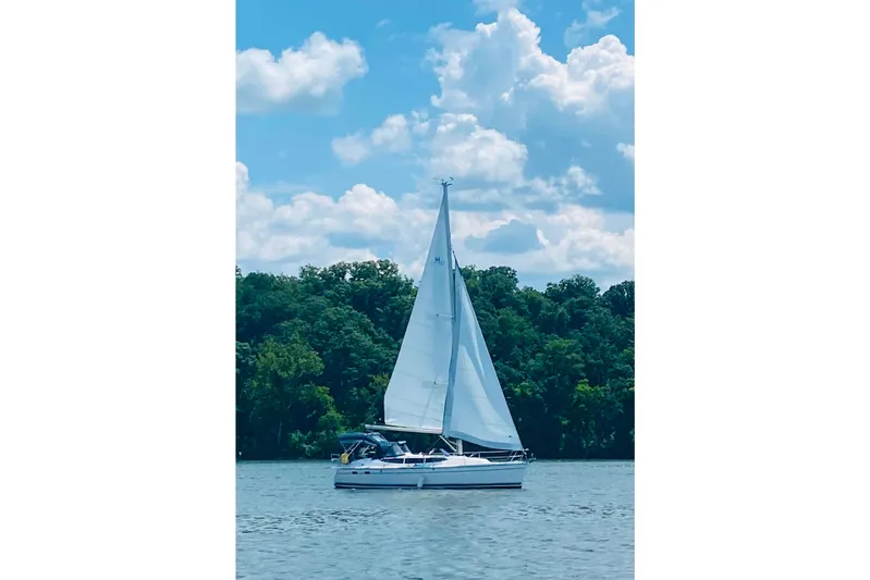  Yacht Photos Pics Sailboat Hunter 33 (2014) cruising on a serene lake under a blue sky.