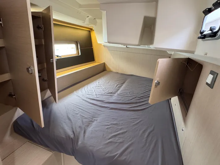 Sensei Yacht Photos Pics 2021 Beneteau Oceanis 46.1 cabin interior with bed and open storage cabinets.