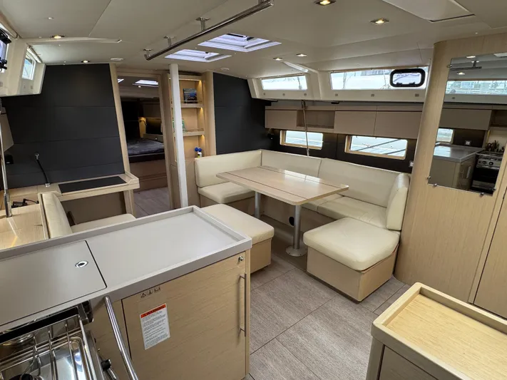 Sensei Yacht Photos Pics Luxurious interior of 2021 Beneteau Oceanis 46.1 yacht with modern dining area and kitchen.