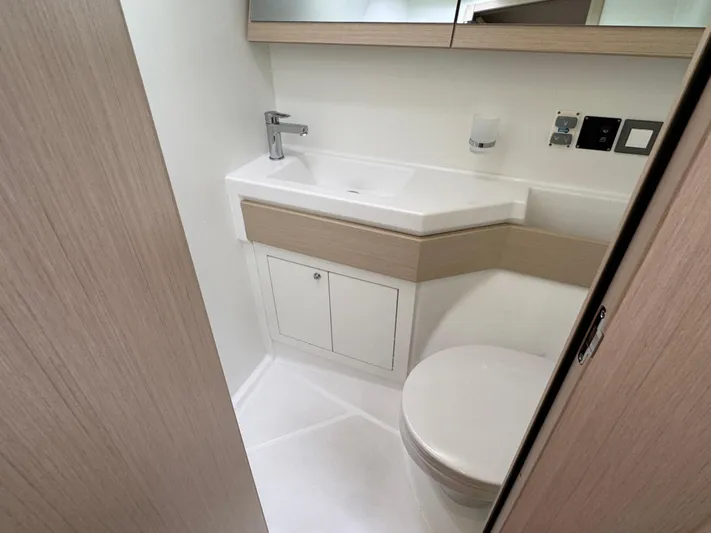 Sensei Yacht Photos Pics Modern bathroom in 2021 Beneteau Oceanis 46.1 yacht, featuring sleek sink and toilet.