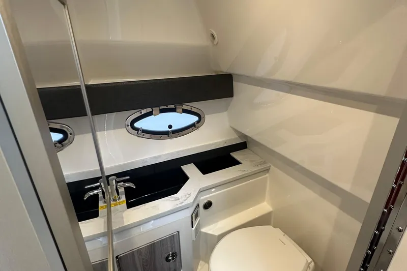  Yacht Photos Pics 2024 Formula 330 CBR boat bathroom with modern sink, toilet, and porthole window.