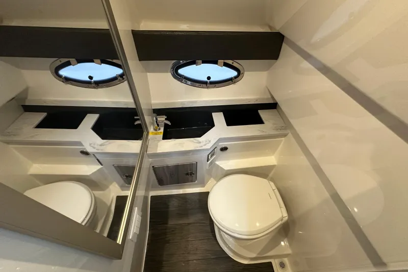  Yacht Photos Pics 2024 Formula 330 CBR boat bathroom with modern fixtures and porthole windows.