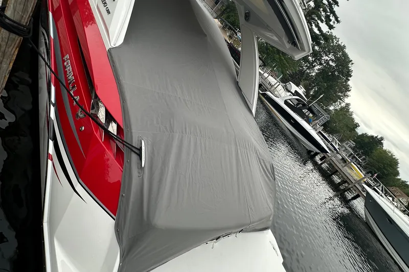  Yacht Photos Pics 2024 Formula 330 CBR boat with cover, docked on a calm lake.
