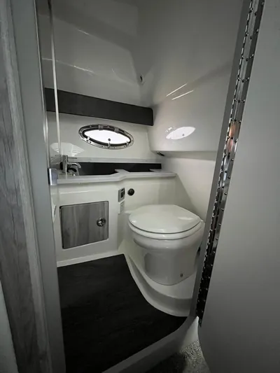  Yacht Photos Pics 2024 Formula 330 Crossover Bowrider I/O bathroom with modern fixtures and porthole window.
