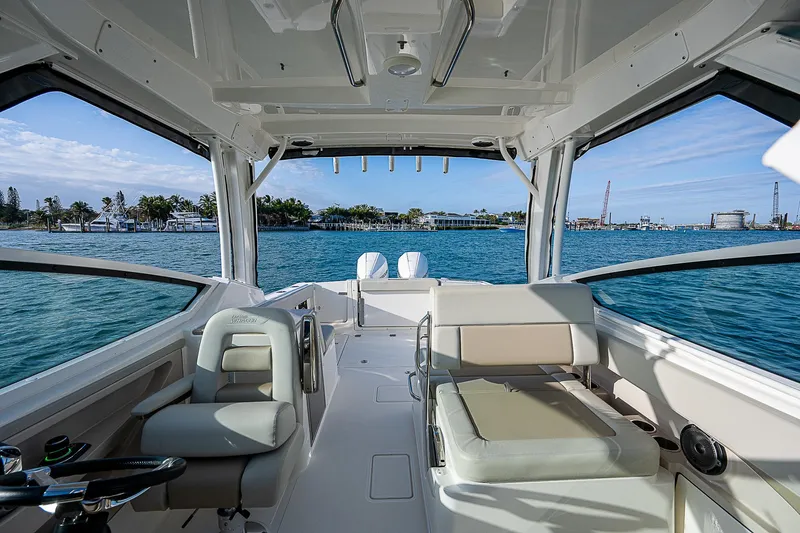  Yacht Photos Pics 2021 Boston Whaler 280 Vantage interior with seating, overlooking a scenic waterfront.