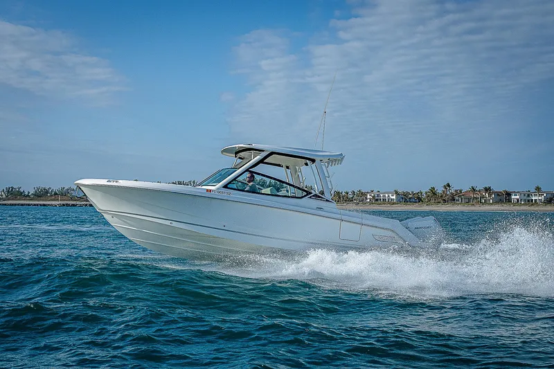  Yacht Photos Pics 2021 Boston Whaler 280 Vantage cruising on open water under a clear blue sky.