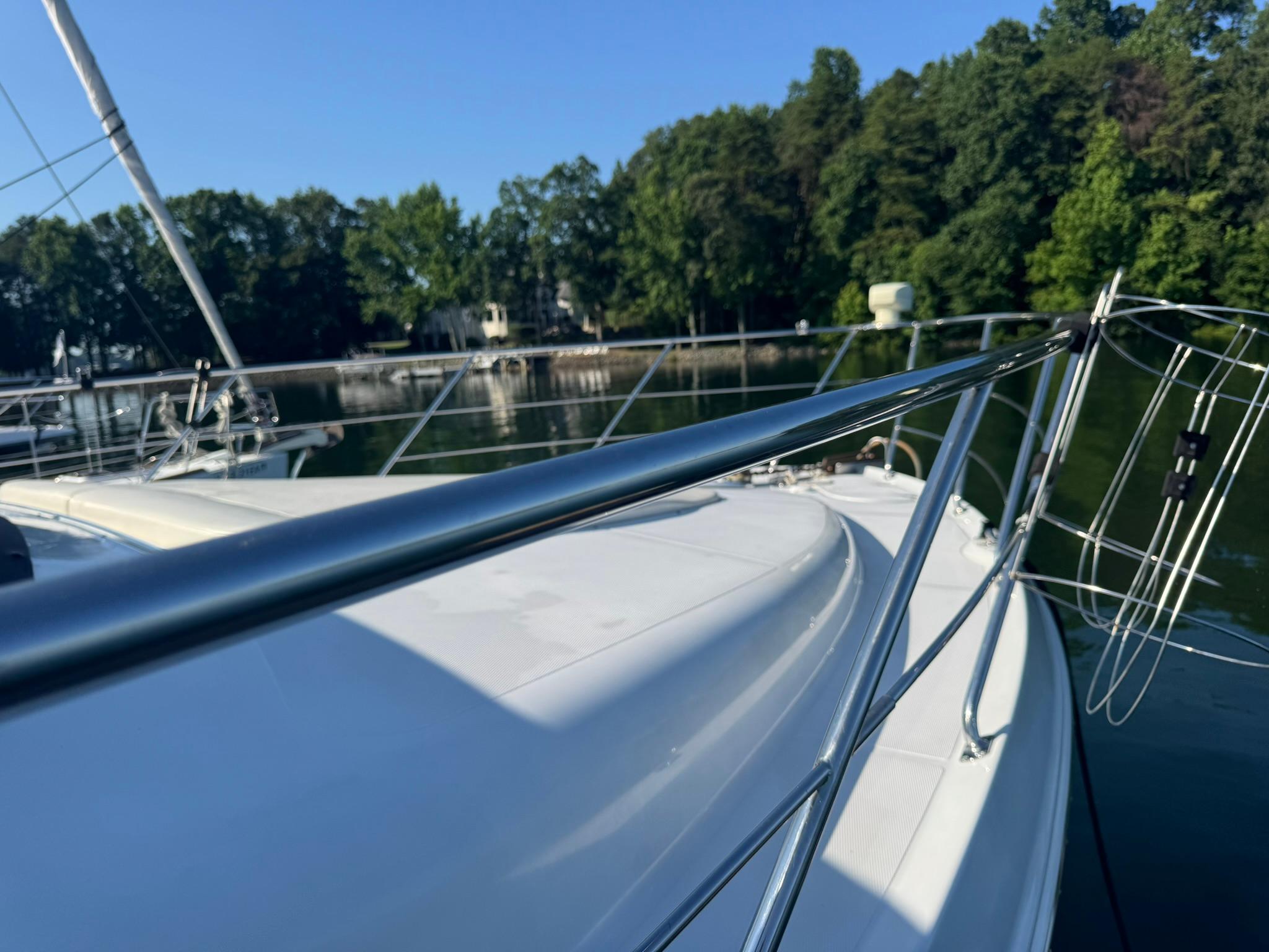 2001 Carver 450 Voyager Pilothouse yacht on a serene lake with lush greenery.
