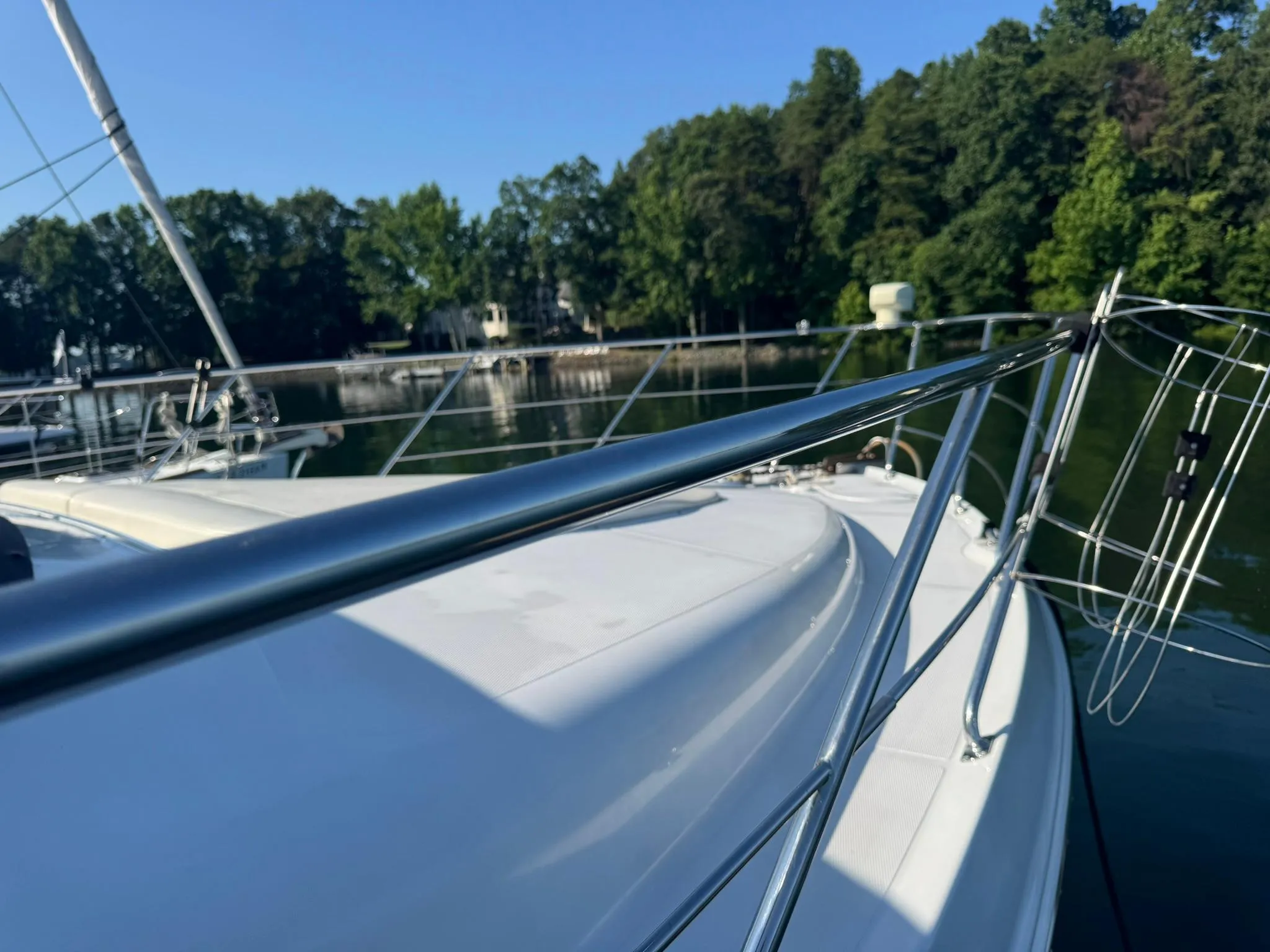 2001 Carver 450 Voyager Pilothouse yacht on a serene lake with lush greenery.