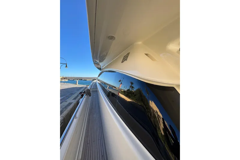  Yacht Photos Pics Side view of 2010 Ferretti Yachts 800 docked, reflecting clear blue sky and waterfront.