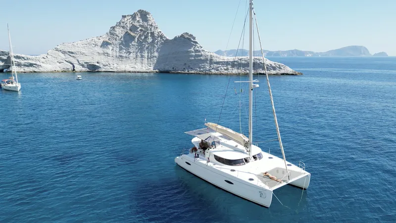 Knotty Nature Yacht Photos Pics Fountaine Pajot Lipari 41 catamaran sailing near rocky coastline, 2011 model.