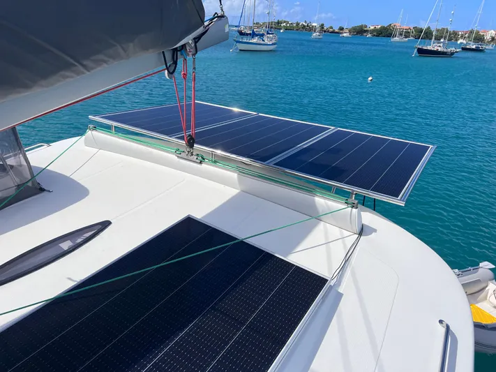 Knotty Nature Yacht Photos Pics Fountaine Pajot Lipari 41 catamaran with solar panels, anchored in a serene bay, 2011 model.