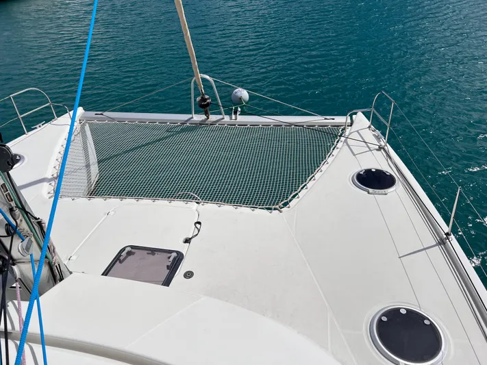Knotty Nature Yacht Photos Pics 2011 Fountaine Pajot Lipari 41 catamaran deck with netting over turquoise water.