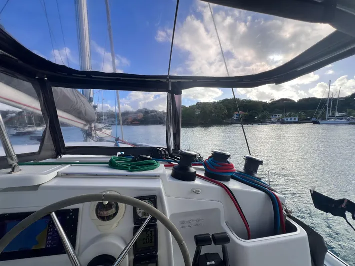 Knotty Nature Yacht Photos Pics View from the helm of a 2011 Fountaine Pajot Lipari 41 catamaran, overlooking calm waters.