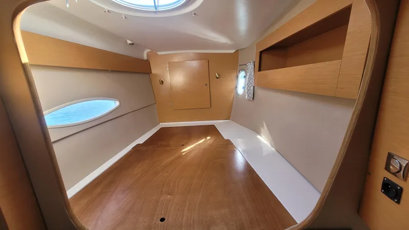 Knotty Nature Yacht Photos Pics Interior cabin of 2011 Fountaine Pajot Lipari 41 catamaran, featuring wood finish and porthole.