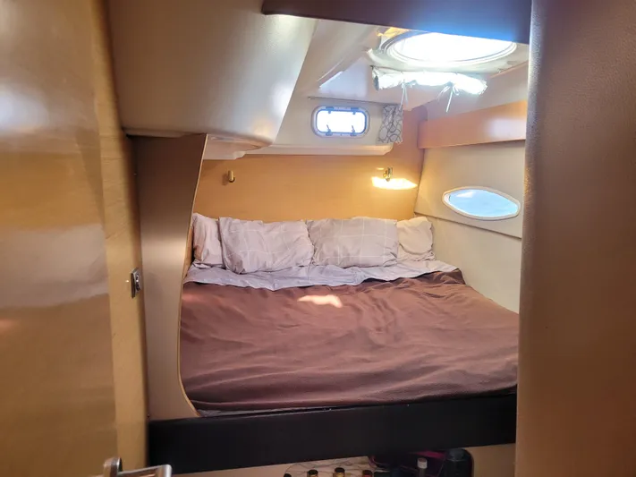 Knotty Nature Yacht Photos Pics Cozy cabin interior of 2011 Fountaine Pajot Lipari 41 catamaran with bed and portholes.