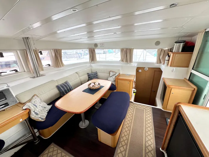 Sunbear Yacht Photos Pics Interior of 2008 Lagoon 420 yacht, featuring a cozy dining area with blue seating.