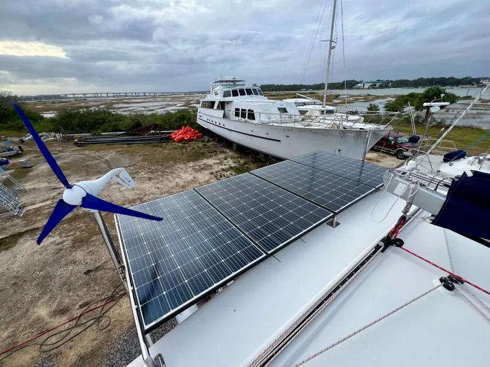 Sunbear Yacht Photos Pics Lagoon 420 catamaran with solar panels and wind turbine, docked near other boats, 2008 model.