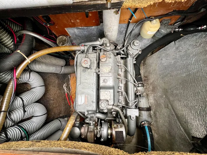 Sunbear Yacht Photos Pics Engine compartment of a 2008 Lagoon 420 catamaran, showcasing mechanical components and hoses.