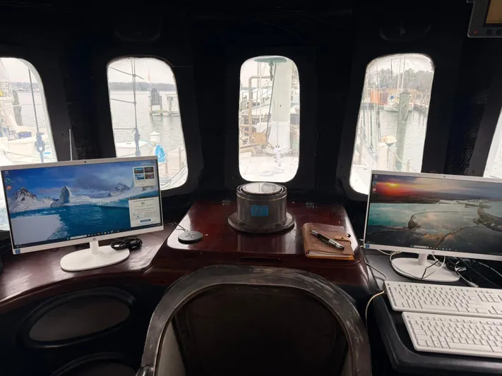 Dauntless Yacht Photos Pics Boat cockpit with dual monitors, keyboards, and marina view through windows.