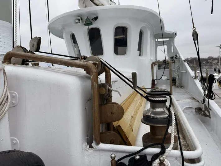 Dauntless Yacht Photos Pics White custom boat deck with ropes and winch, 1990 model, docked on a cloudy day.