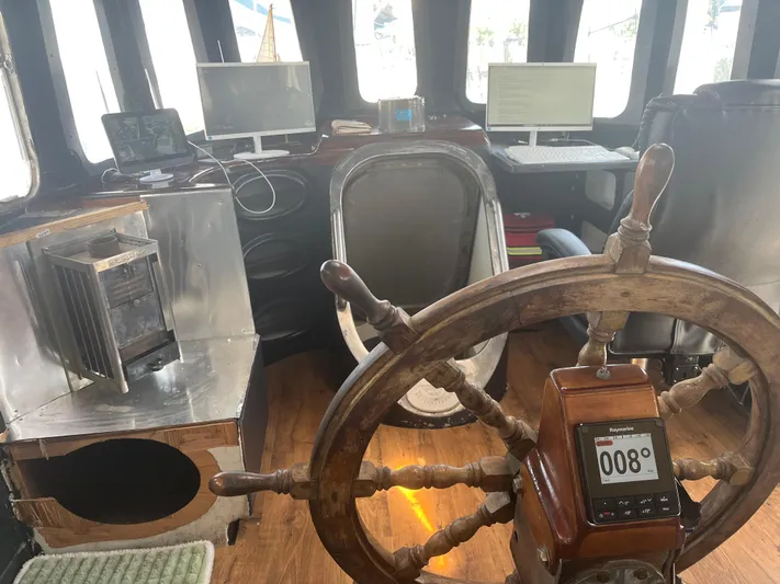 Dauntless Yacht Photos Pics Vintage ship's helm with modern navigation, computers, and wood stove in a custom 1990 vessel.