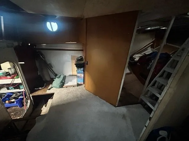 Dauntless Yacht Photos Pics Dimly lit interior of a 1990 custom model, featuring storage and a ladder.