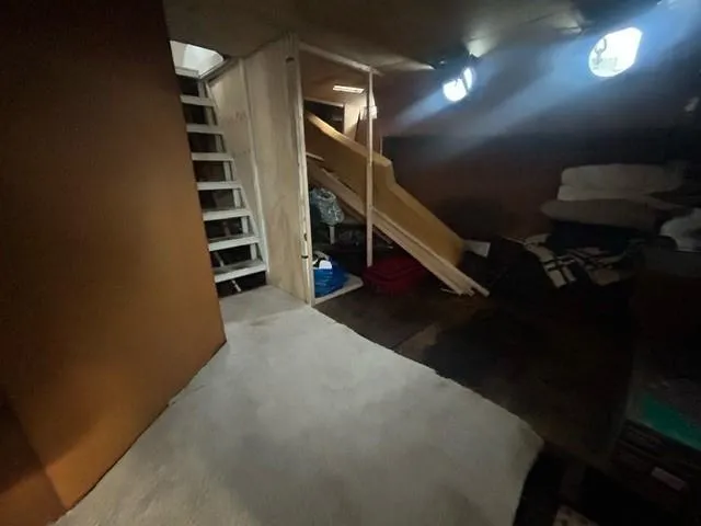 Dauntless Yacht Photos Pics Interior of a custom 1990 boat with stairs, carpet, and porthole windows.