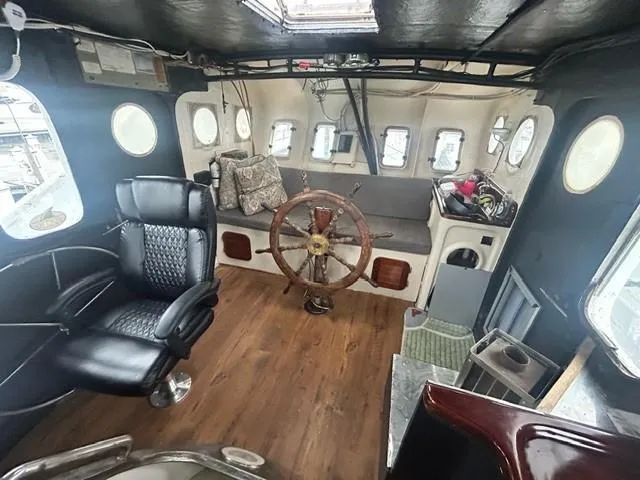 Dauntless Yacht Photos Pics Interior of a vintage 1990 custom boat with wooden steering wheel and leather seating.