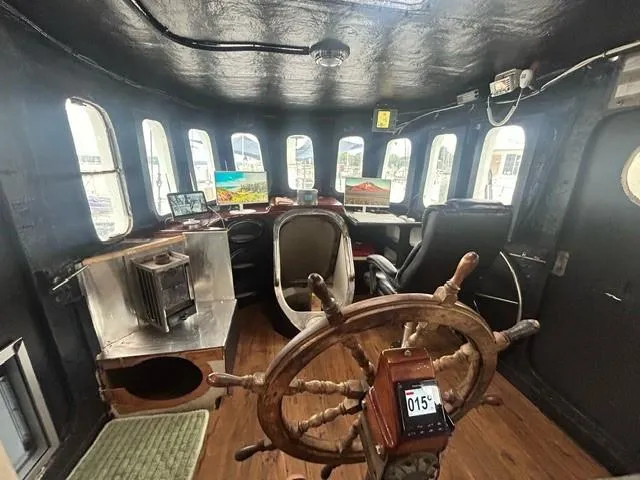 Dauntless Yacht Photos Pics Vintage ship's wheelhouse interior with wooden steering wheel, multiple windows, and navigation equipment, 1990.