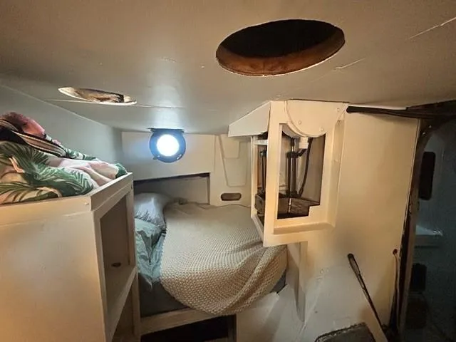 Dauntless Yacht Photos Pics Cozy boat cabin interior with bed, porthole, and storage, 1990 custom model.