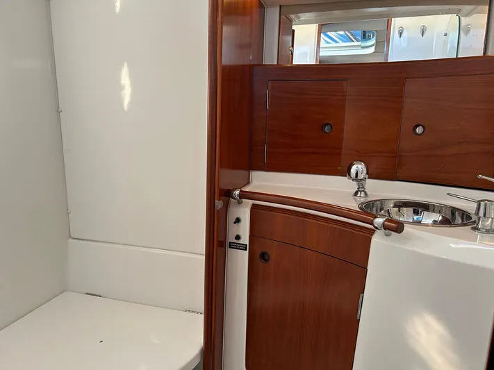 Veronese Yacht Photos Pics Beneteau First 47.7 2003 yacht bathroom with wooden cabinetry and stainless steel sink.