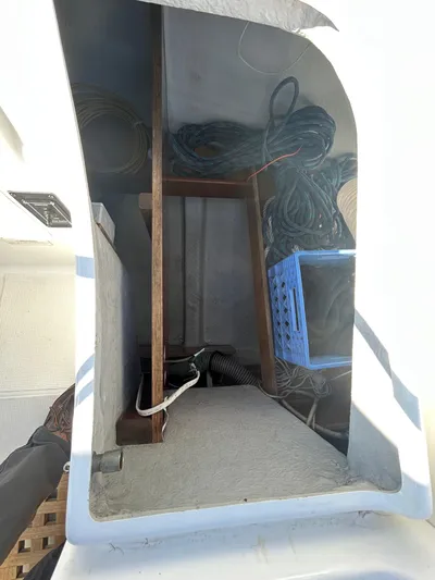 Veronese Yacht Photos Pics Storage compartment on a 2003 Beneteau First 47.7 sailboat, featuring ropes and a blue crate.
