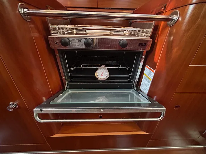 Veronese Yacht Photos Pics Open oven in 2003 Beneteau First 47.7 yacht kitchen, showcasing wooden cabinetry.