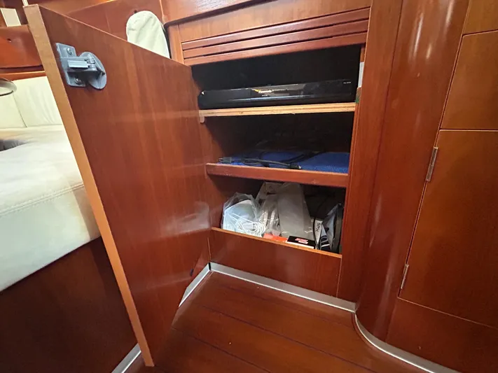 Veronese Yacht Photos Pics Open wooden cabinet with shelves inside a 2003 Beneteau First 47.7 sailboat interior.