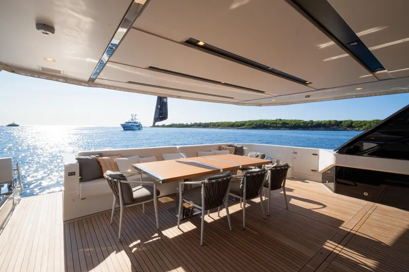 Le Gypsy Yacht Photos Pics Luxurious 2018 Sanlorenzo 102A yacht deck with dining area, overlooking serene ocean view.