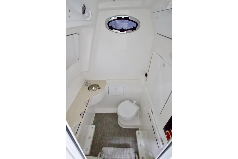 31-406 Yacht Photos Pics 2026 Regulator 31 boat interior with compact bathroom, featuring a toilet, sink, and storage.