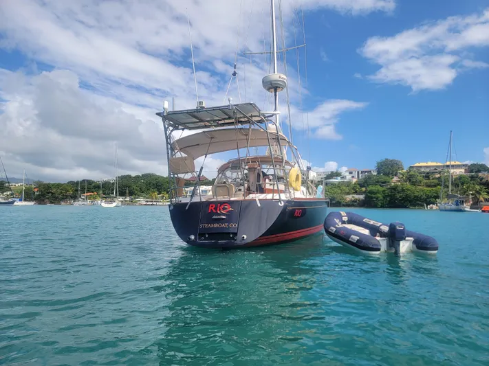 Rio Yacht Photos Pics Sailboat Tartan 4300 (2008) anchored in a scenic bay with clear blue skies.