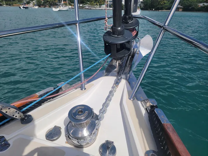 Rio Yacht Photos Pics Bow of 2008 Tartan 4300 sailboat with anchor chain and winch on calm water.