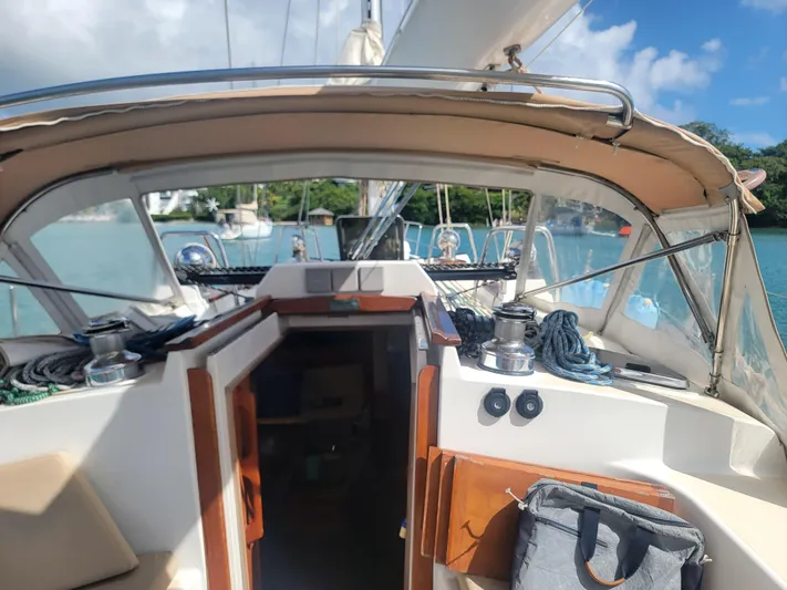 Rio Yacht Photos Pics 2008 Tartan 4300 sailboat cockpit with open cabin door, docked in a serene marina.