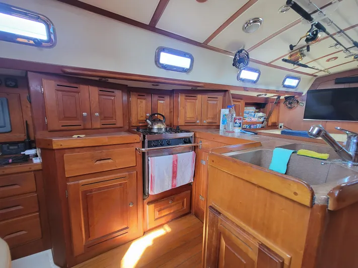 Rio Yacht Photos Pics Interior of 2008 Tartan 4300 sailboat kitchen with wooden cabinetry and appliances.