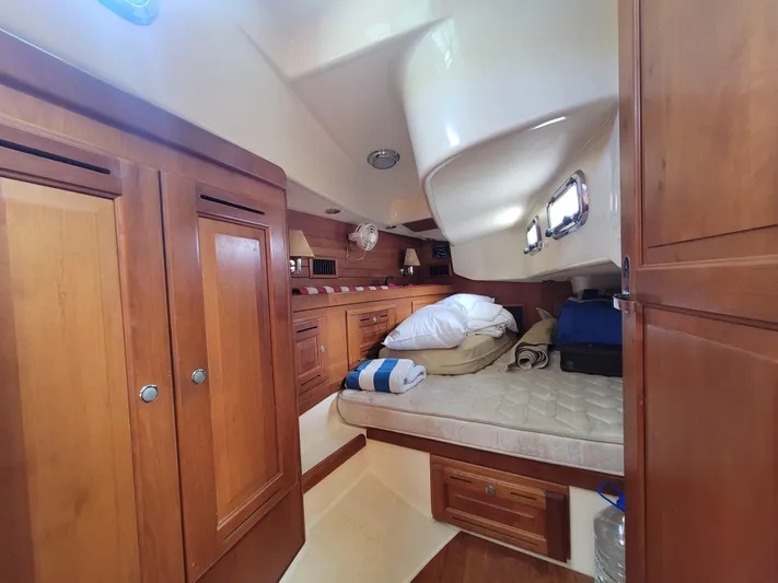 Rio Yacht Photos Pics Cozy cabin interior of 2008 Tartan 4300 sailboat with wooden furnishings and bedding.