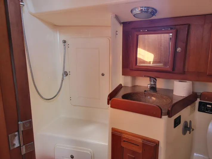 Rio Yacht Photos Pics Interior of 2008 Tartan 4300 yacht bathroom with shower and wooden cabinetry.