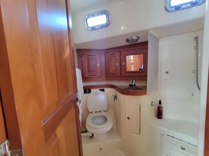 Rio Yacht Photos Pics 2008 Tartan 4300 yacht bathroom with wooden cabinets and white fixtures.