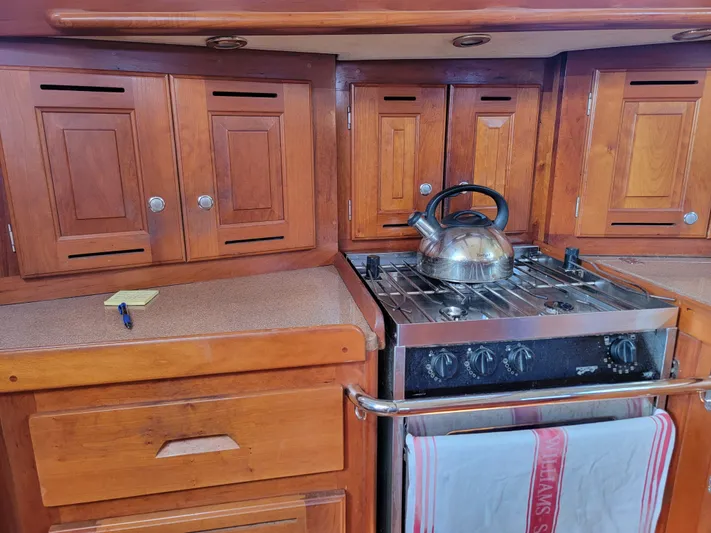 Rio Yacht Photos Pics Wooden kitchen interior of 2008 Tartan 4300 yacht with stove and kettle.