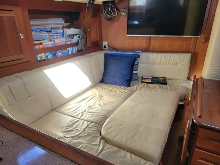 Rio Yacht Photos Pics Cozy Tartan 4300 yacht interior with cream leather seating, blue pillow, and bookshelf.