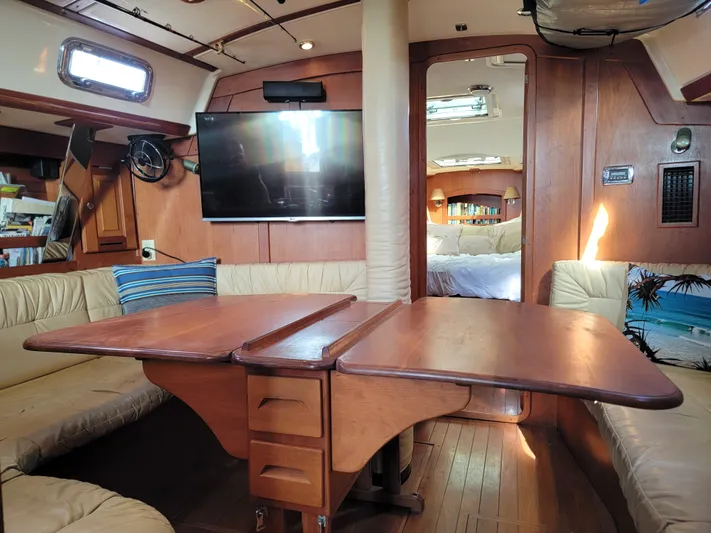Rio Yacht Photos Pics Interior of 2008 Tartan 4300 yacht with wooden table, seating, and TV.
